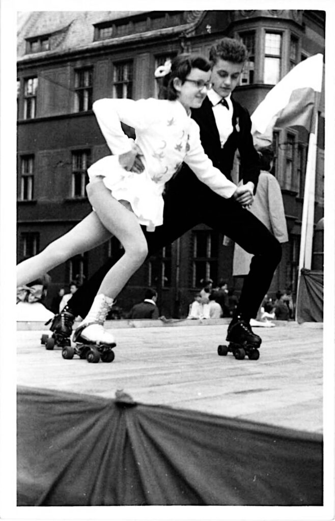 Dwoje młodych ludzi jeździ na wrotkach na drewnianej platformie